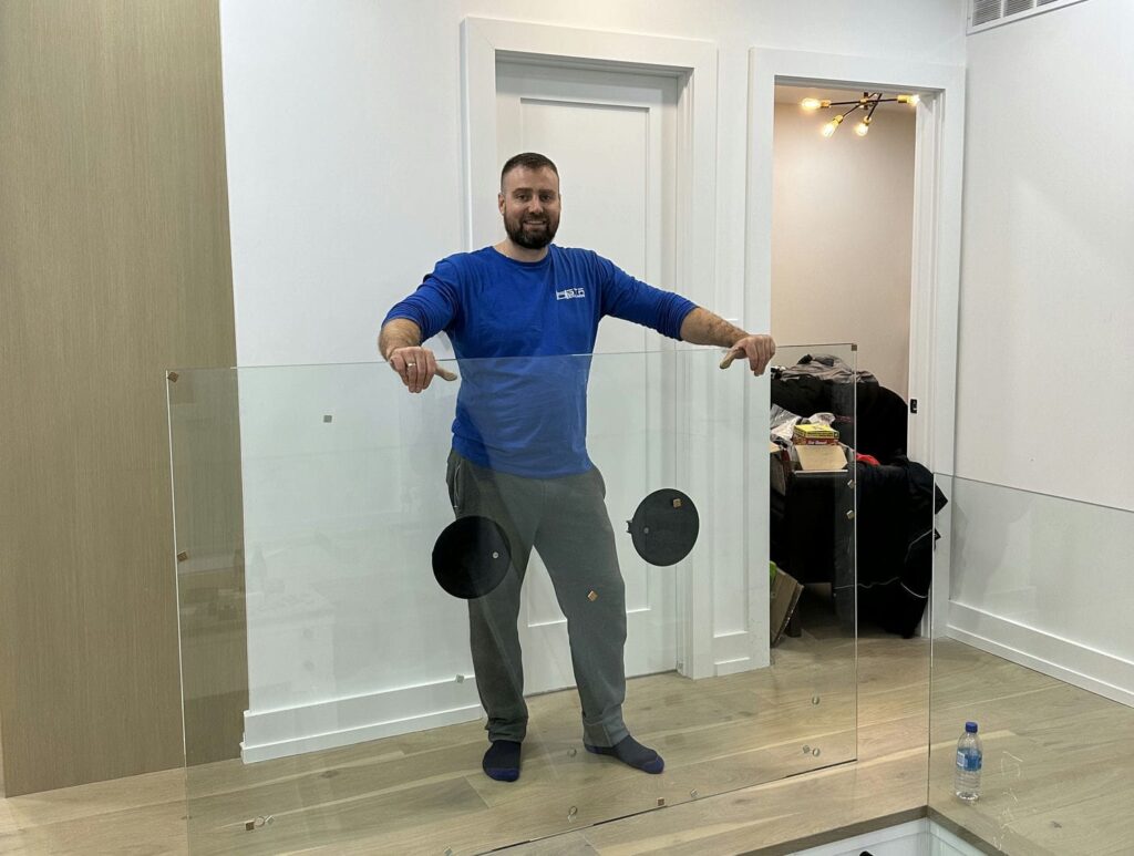 gta glass railing installer posing next to glass railing