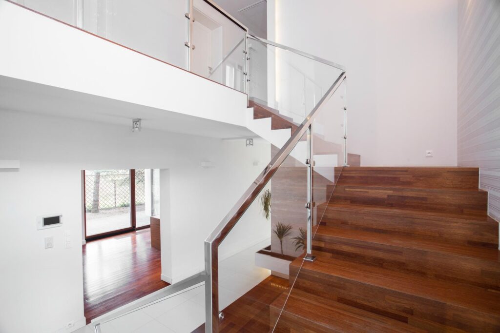 Modern indoor glass stair railing with low-profile hardware and slim handrail showing design, safety, and layout integration