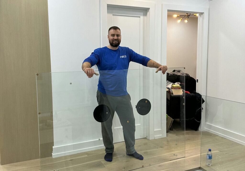 gta glass railing installer posing next to glass railing