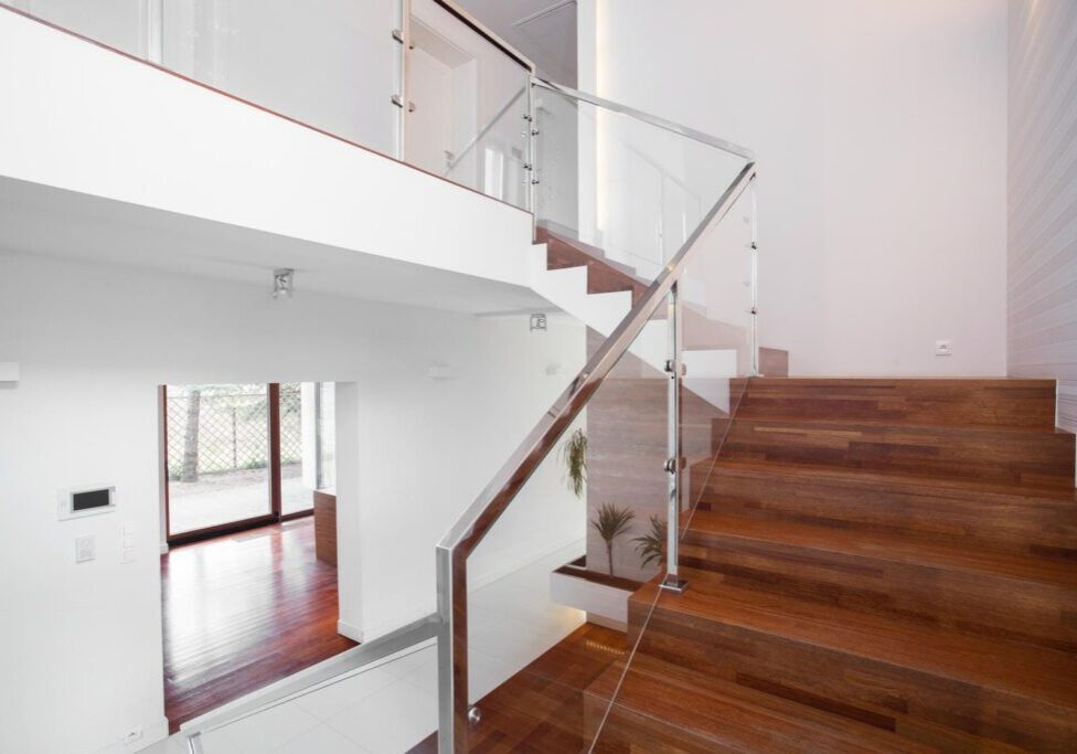 Modern indoor glass stair railing with low-profile hardware and slim handrail showing design, safety, and layout integration